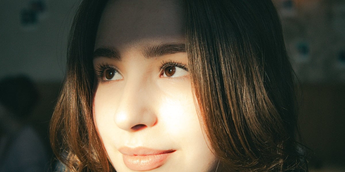Portrait of thoughtful young woman showcasing natural beauty and facial features for volume restoration treatments
